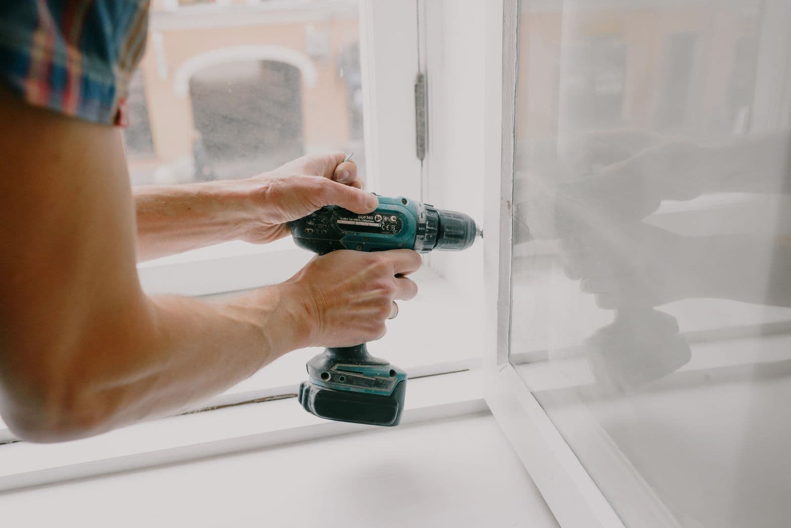 Technician fitting an aluminium window frame